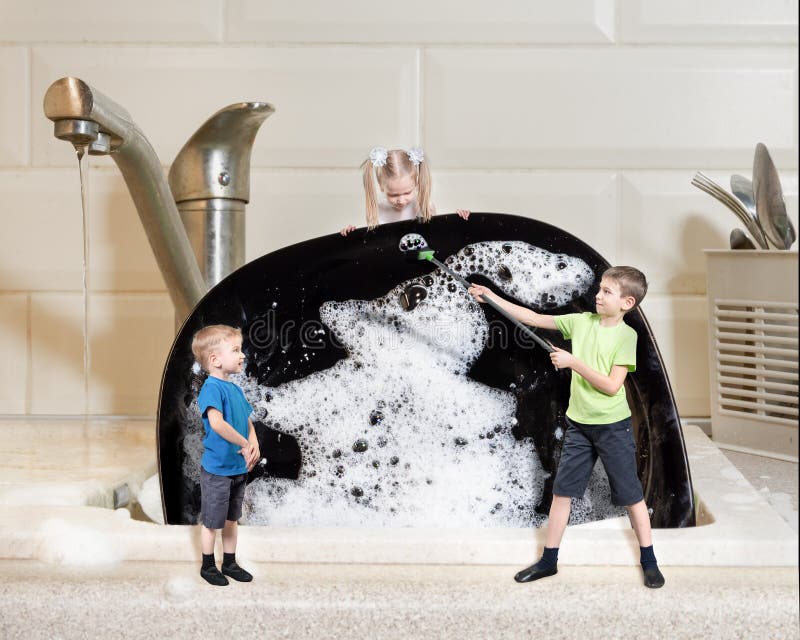 Creative work: three miniature children wash a large black plate with foam. Homework concept