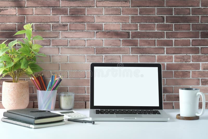 Creative Workplace with Laptop Computer, Coffee Cup, Pencil Holder and Houseplant on White Table