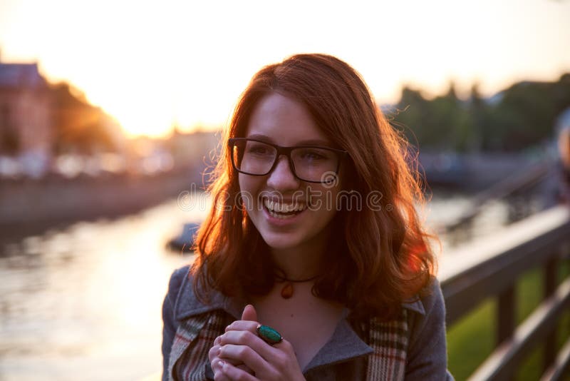 Happy young woman smiling with teeth smile outdoors and walking on city street at sunset time weating winter clothes and knitted s stock image Happy young woman smiling with teeth smile outdoors and walking on city street at sunset time weating winter clothes and knitted s stock image
