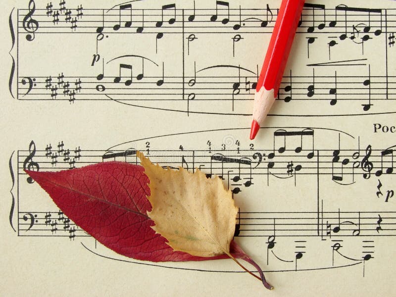 Old sheet of musical symbols with colorful autumnal leaves and red pencil fragment. Colorful musical notes stock images, royalty-free photos and pictures