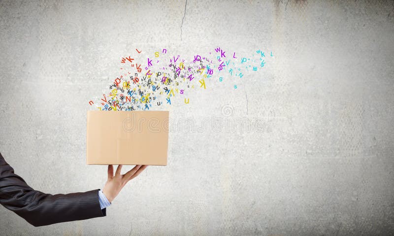 Close up of hand holding carton box with colorful letters. Close up of hand holding carton box with colorful letters