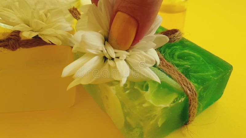 Crema cosmética, cámara lenta de la flor natural del crisantemo en un fondo amarillo