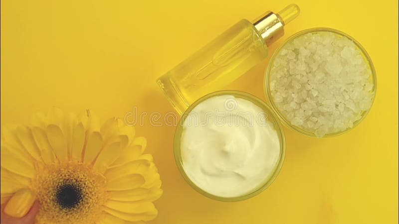 Crema cosmética, gerbera en un fondo amarillo