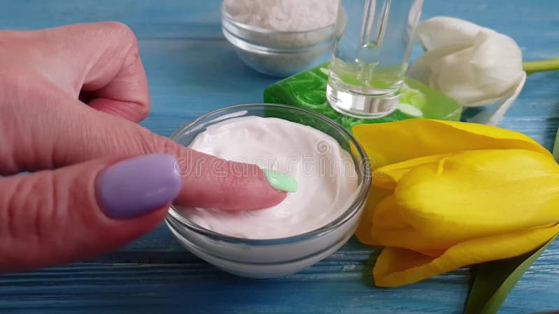 Crema cosmética, manicura de la mano del tulipán en un fondo