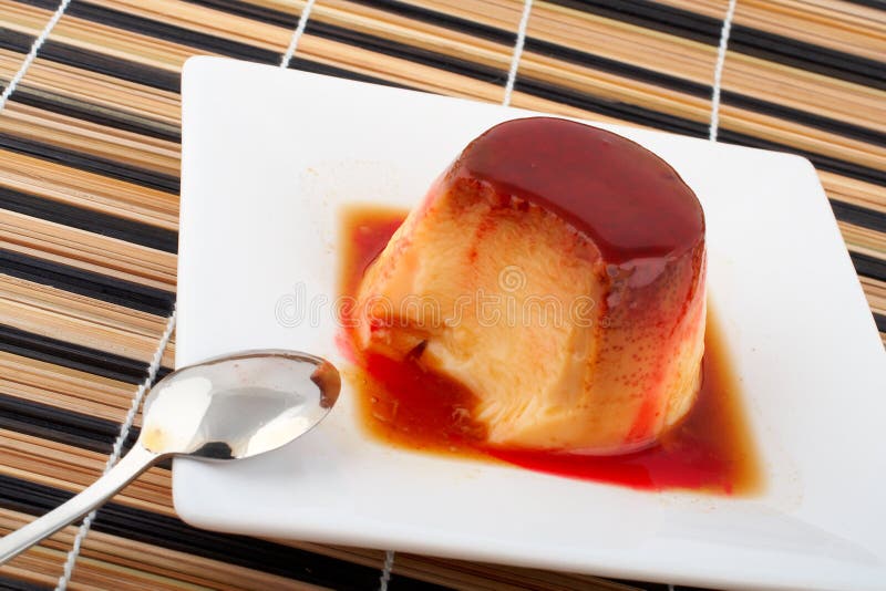 Crema della vaniglia e dessert della caramella con il cucchiaio sul piatto bianco fotografia stock