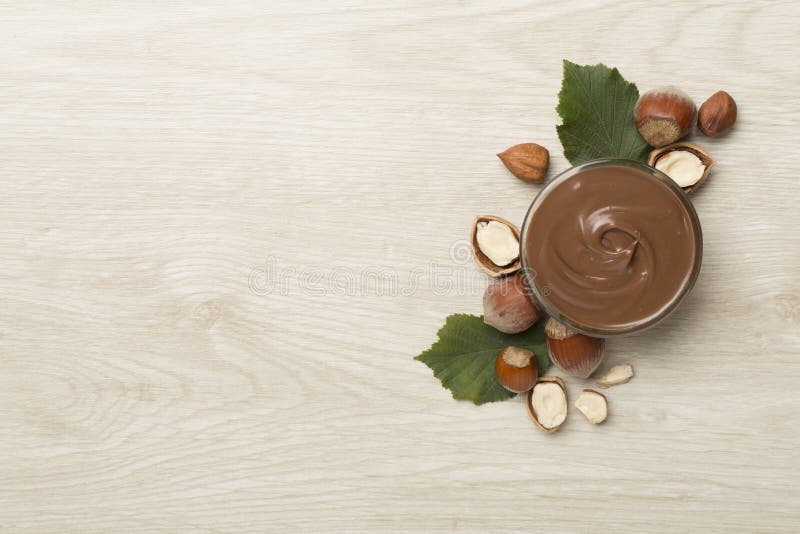 Crema di nocciole con nocciole con nocciole in vista superiore di sfondo di legno fotografia stock libera da diritti