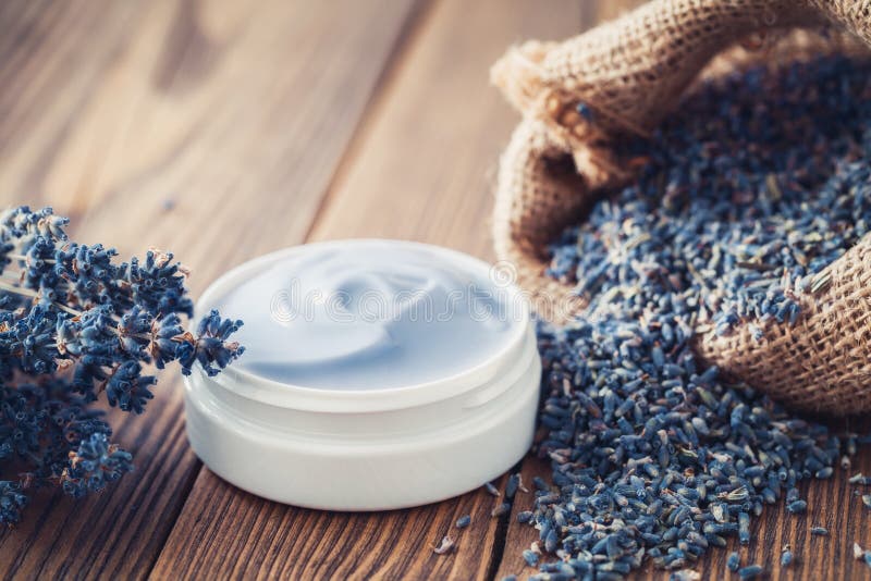 Creme da alfazema ou saco do bálsamo e da juta da alfazema seca. Creme ou bálsamo da alfazema, saco da juta da alfazema seca e grupo de flores secadas