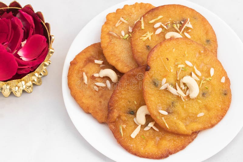 Cremige indische Mithai Dessert mawa malpua mit Khoya und Ghee geladen und mit Nüssen trockenen Früchten in Teller mit Rose servie lizenzfreie stockfotografie