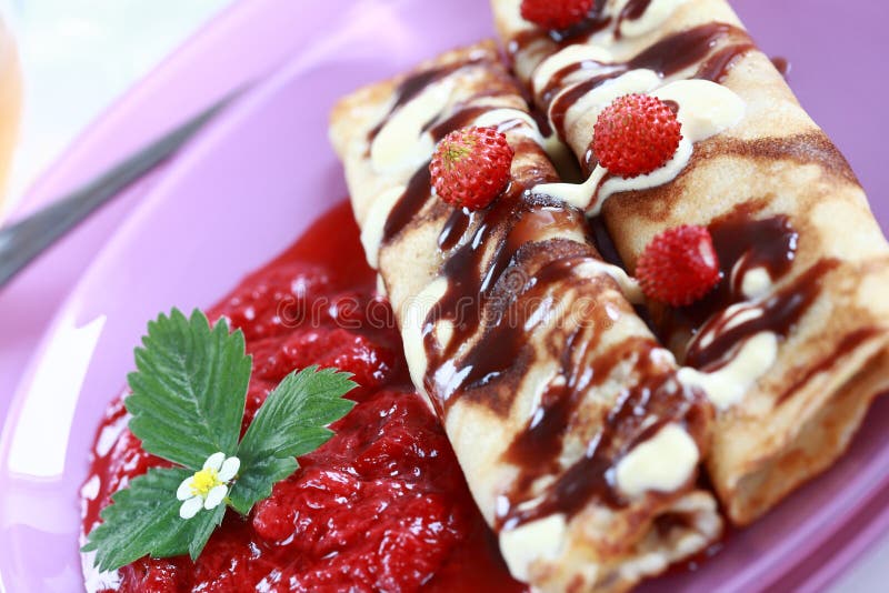 Delicious crepes with strawberry sauce and chocolate