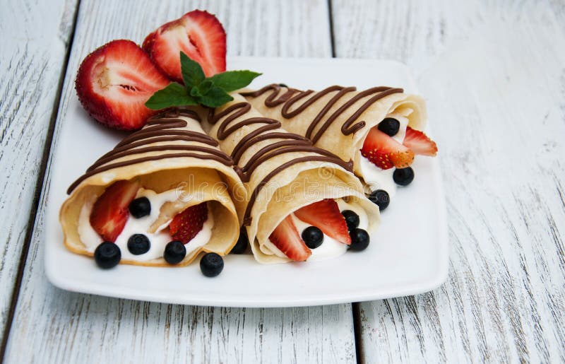Crepes com morangos e molho de chocolate imagens de stock royalty free