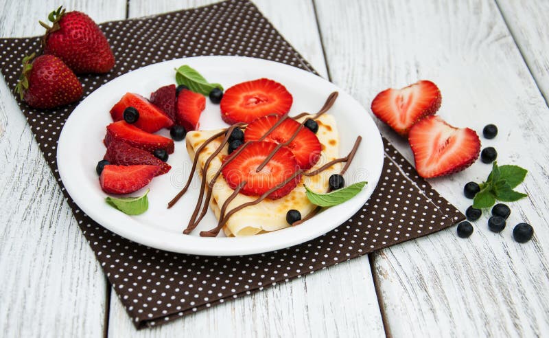 Crepes com morangos e molho de chocolate imagens de stock royalty free