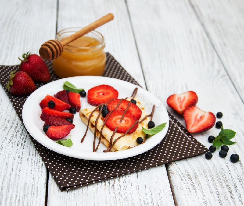 Crepes com morangos e molho de chocolate imagem de stock