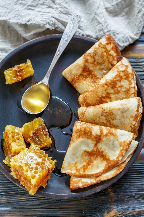 Crepes e mel para um café da manhã delicioso fotografia de stock Crepes e mel para um café da manhã delicioso fotografia de stock