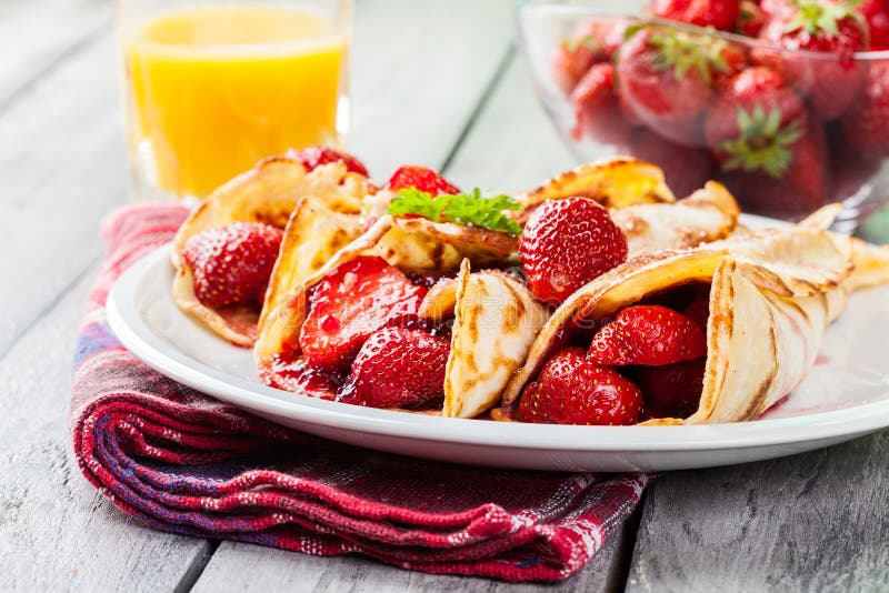 Crepes tradicionais servidas com morangos imagens de stock