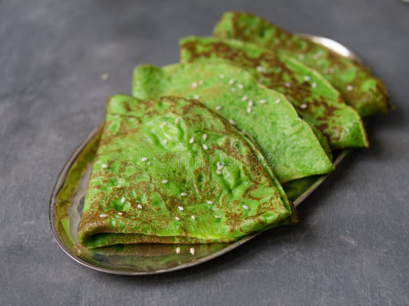Crepes verdes da hortelã na placa de metal no fundo cinzento Feche acima, foco seletivo Café da manhã gourmet Maslenitsa Crepes f fotografia de stock Crepes verdes da hortelã na placa de metal no fundo cinzento Feche acima, foco seletivo Café da manhã gourmet Maslenitsa Crepes f fotografia de stock