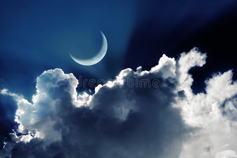 Crescent moon in a beautiful night sky with glowing clouds royalty free stock photo