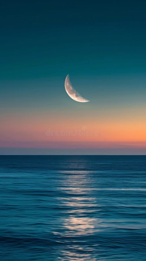 Crescent moon over calm ocean at sunset, serene twilight scene stock photo