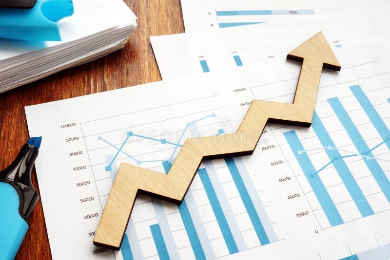 Crescimento do negócio Seta de madeira e relatórios financeiros foto de stock Crescimento do negócio Seta de madeira e relatórios financeiros foto de stock