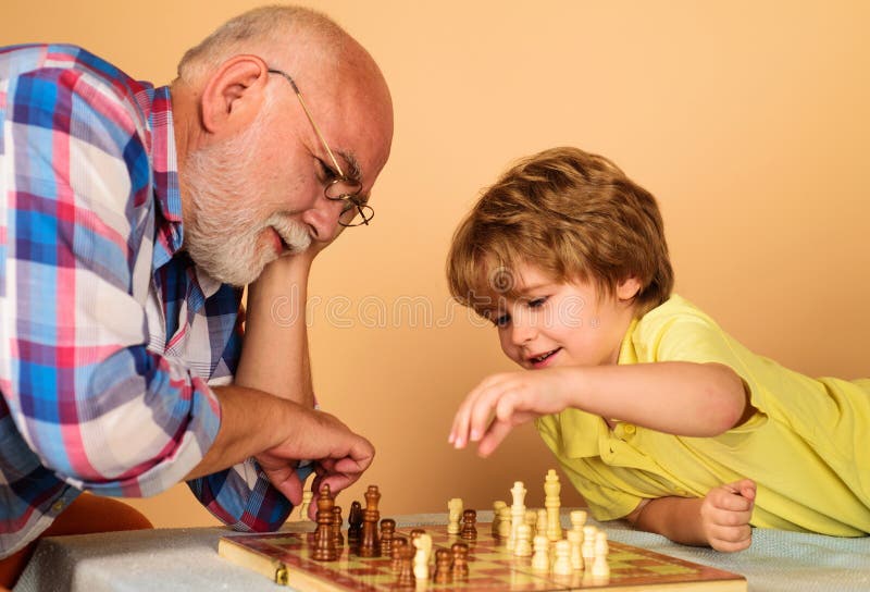 Competição de xadrez infantil e de tabuleiro, garotinho jogando xadrez com  o vovô.