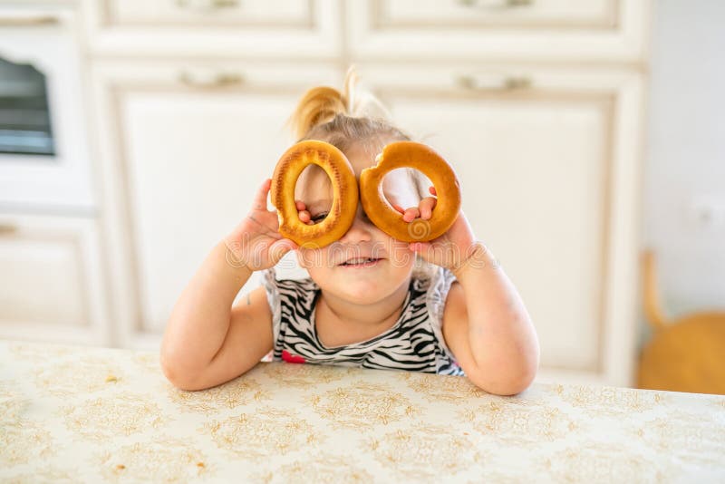 Feliz Bebê Loira Com Duas Pequenas Tranças Em Camiseta Branca E Um Kit De  Calças Jeans Sentado Sobre O Fundo Da Grama Verde Foto de Stock - Imagem de  pouco, inocência: 143643548