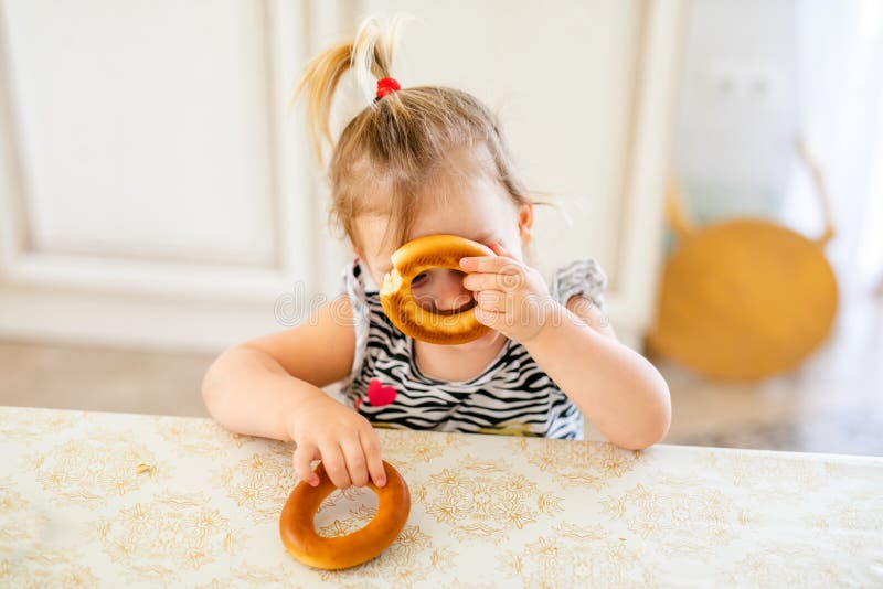 Feliz Bebê Loira Com Duas Pequenas Tranças Em Camiseta Branca E Um Kit De  Calças Jeans Sentado Sobre O Fundo Da Grama Verde Foto de Stock - Imagem de  pouco, inocência: 143643548