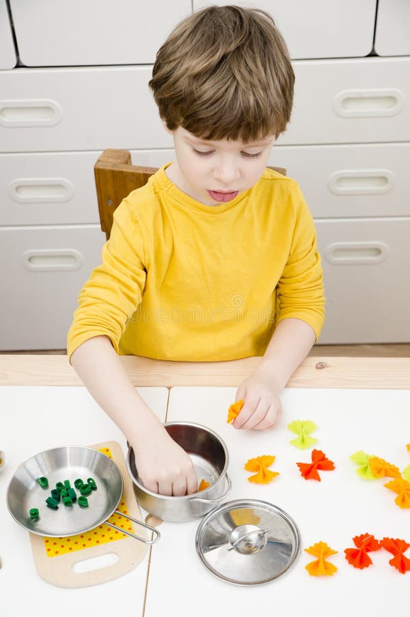 A Criança Prepara Comida De Brinquedo Na Cozinha Do Brinquedo. Imagem de  Stock - Imagem de infantil, alegria: 252436401