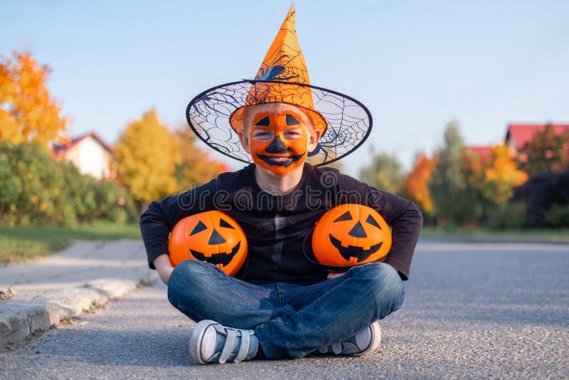 Crianças do dia das bruxas garotinho engraçado usando um chapéu de bruxa  com balões laranja e pretos feliz dia das bruxas