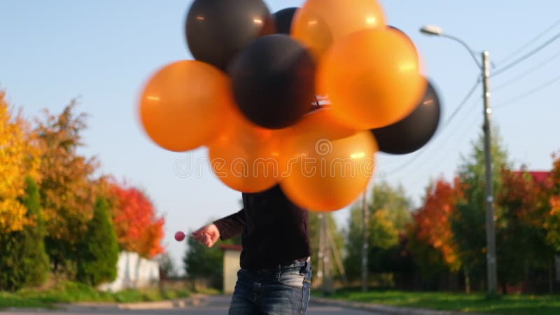 Crianças do dia das bruxas garotinho engraçado usando um chapéu de bruxa  com balões laranja e pretos feliz dia das bruxas