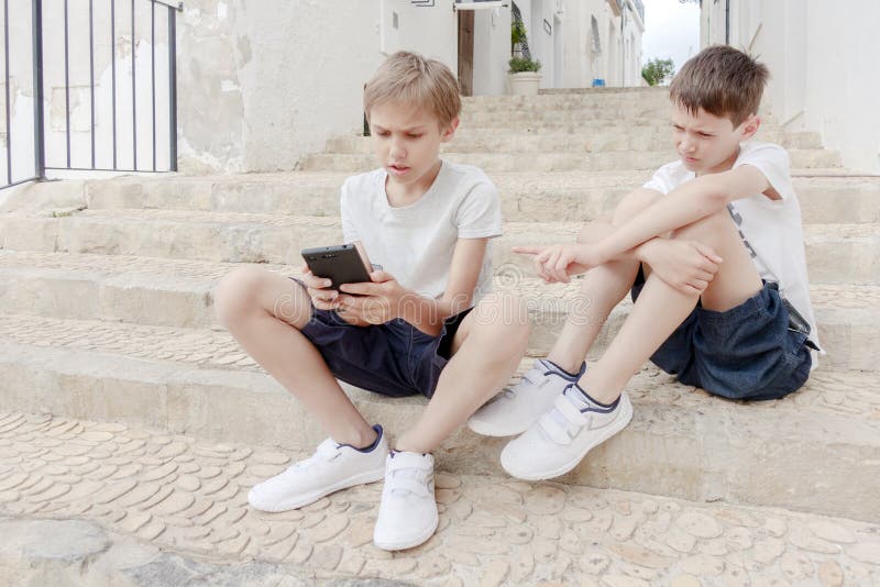 Crianças Com O Telefone Celular Exterior Dois Meninos Que Sorriem