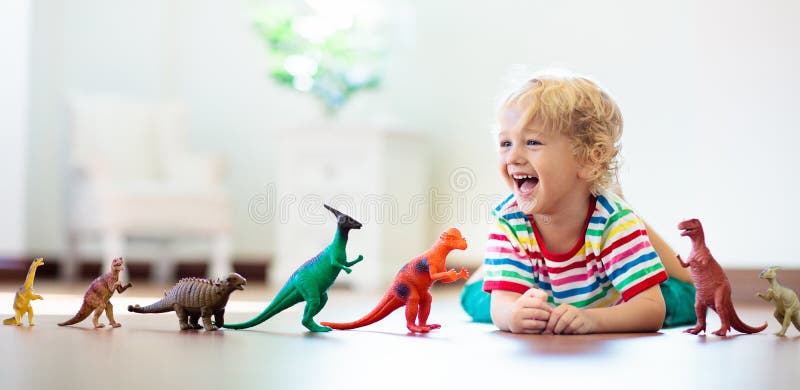 Crian?a que joga com dinossauros do brinquedo Brinquedos das crian?as