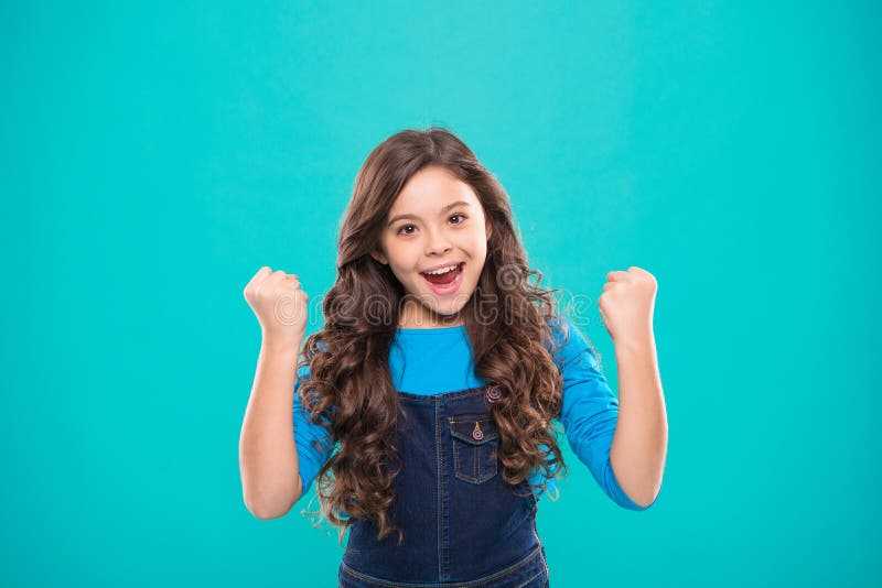 A criança alegre comemora a vitória Sorriso feliz longo do cabelo encaracolado da criança bonito da menina Psicologia e desenvolv imagem de stock royalty free A criança alegre comemora a vitória Sorriso feliz longo do cabelo encaracolado da criança bonito da menina Psicologia e desenvolv imagem de stock royalty free