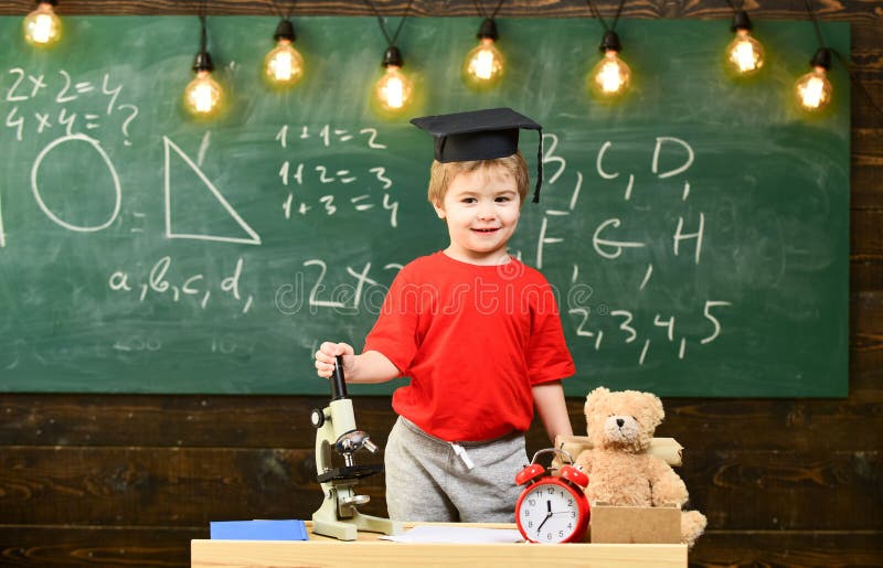 Criança, aluno na cara de sorriso perto do microscópio Primeiro interessado anterior no estudo, educação Conceito do Wunderkind m foto de stock Criança, aluno na cara de sorriso perto do microscópio Primeiro interessado anterior no estudo, educação Conceito do Wunderkind m foto de stock