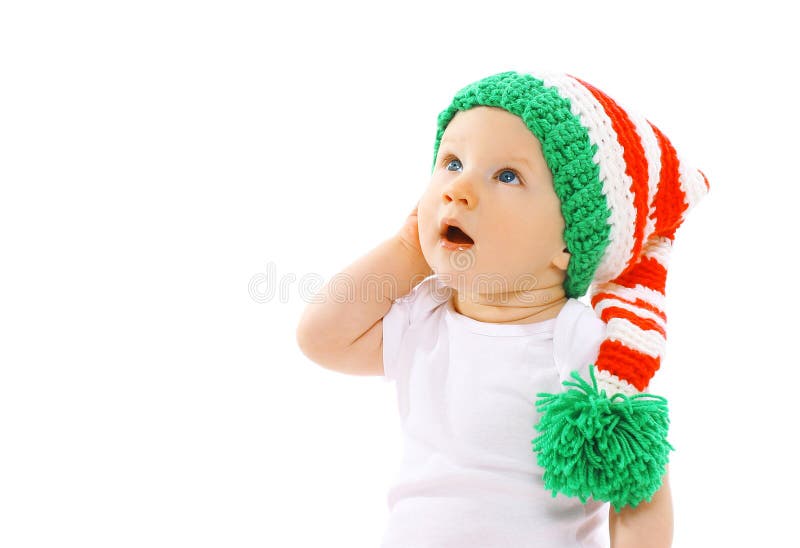 A criança bonito no chapéu feito malha do gnomo surpreendeu a vista acima em um branco fotos de stock A criança bonito no chapéu feito malha do gnomo surpreendeu a vista acima em um branco fotos de stock