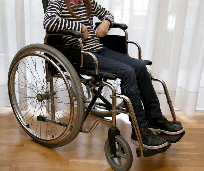 Criança Deficiente Nova Em Uma Cadeira De Rodas Em Seu Quarto Imagem de