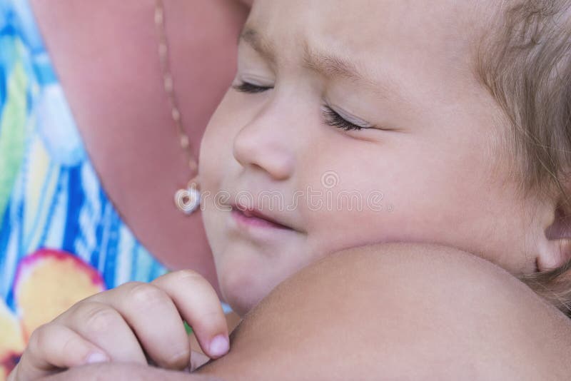 A criança dorme com sua mãe nos braços imagens de stock A criança dorme com sua mãe nos braços imagens de stock