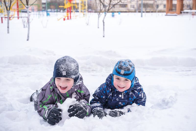 An adorable preschooler in winter wear sit amoung snow and play with toy reindeer. An adorable preschooler in winter wear sit amoung snow and play with toy reindeer.