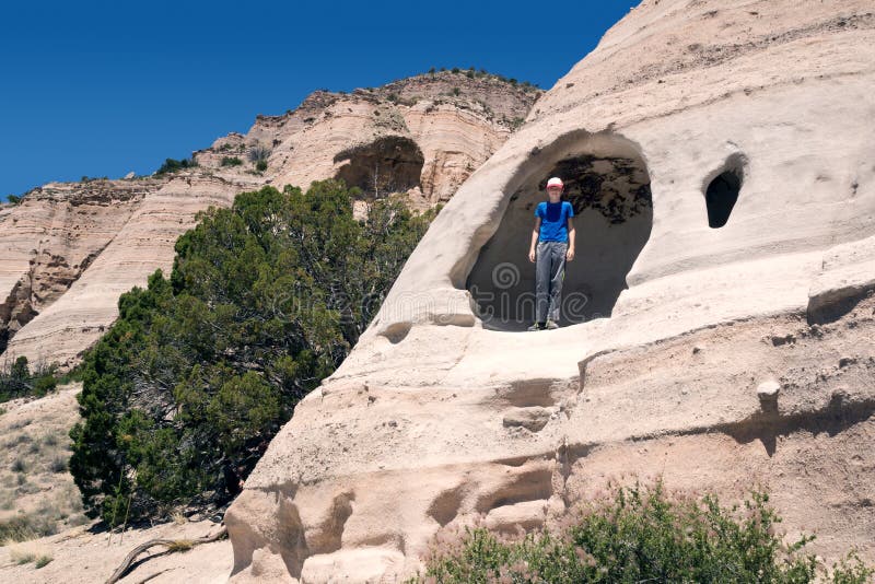 A criança está numa alcova semelhante a uma gruta. Kasha-Katuwe Tent Rocks National Monument imagens de stock