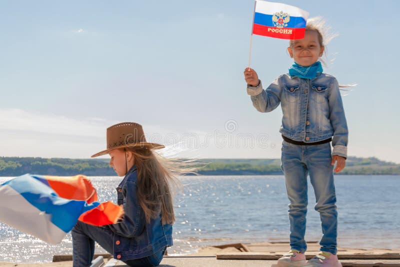 Criança feliz, menina bonito da criança pequena com bandeira de Rússia contra um céu azul claro fotografia de stock royalty free Criança feliz, menina bonito da criança pequena com bandeira de Rússia contra um céu azul claro fotografia de stock royalty free