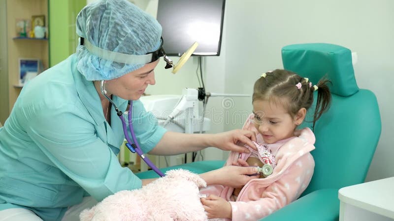 Criança feliz na recepção do ` s do doutor, criança doente do exame médico, estetoscópio de escuta dos pulmões das crianças, trat