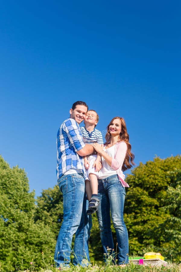 Criança levando da família, pais que estão no prado foto de stock royalty free Criança levando da família, pais que estão no prado foto de stock royalty free
