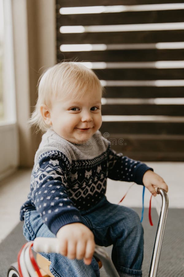 A criança loura pequena bonito adorável preciosa do menino da criança do bebê que joga fora em Toy Bicycle Scooter Mobile Smiling imagens de stock royalty free A criança loura pequena bonito adorável preciosa do menino da criança do bebê que joga fora em Toy Bicycle Scooter Mobile Smiling imagens de stock royalty free