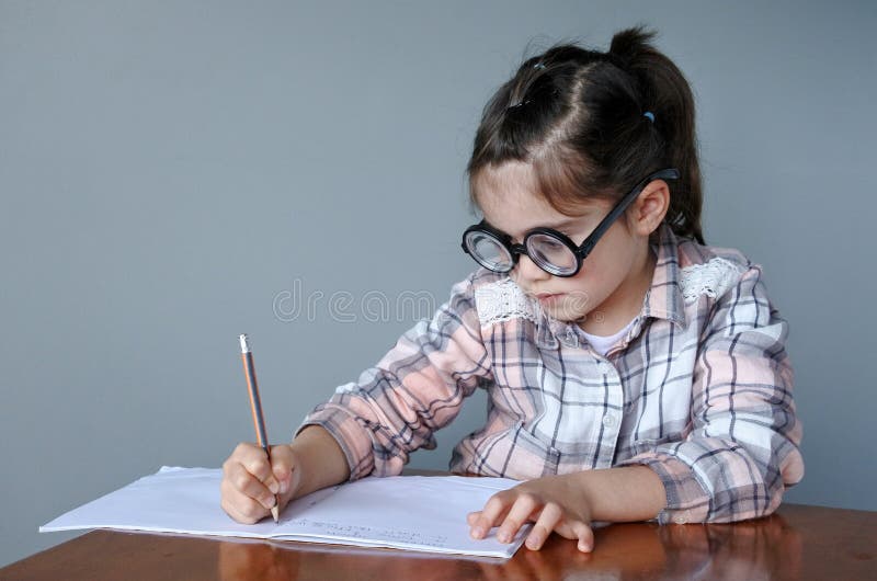 A criança Nerdy escreve uma história imagem de stock royalty free