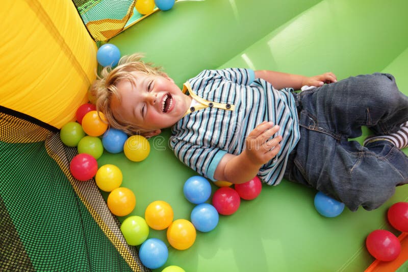 Criança no castelo bouncy inflável foto de stock royalty free Criança no castelo bouncy inflável foto de stock royalty free
