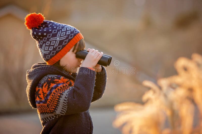 Criança adorável, um menino, a explorar a natureza com binóculos fotos de stock
