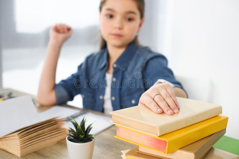criança preteen adorável que toma livros na tabela imagens de stock criança preteen adorável que toma livros na tabela imagens de stock