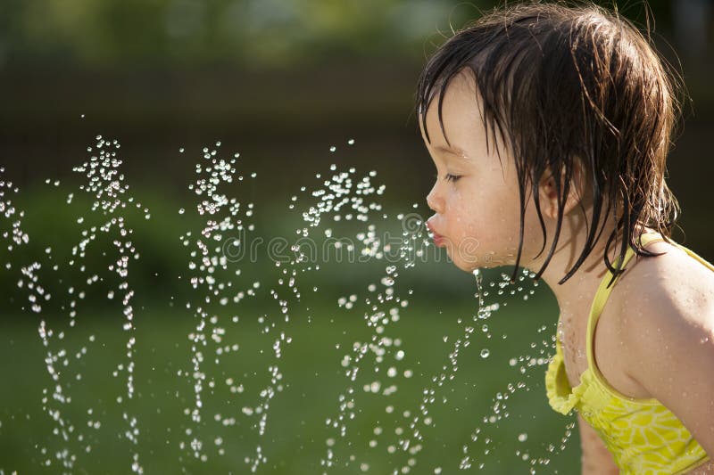 Criança que bebe da fonte de água