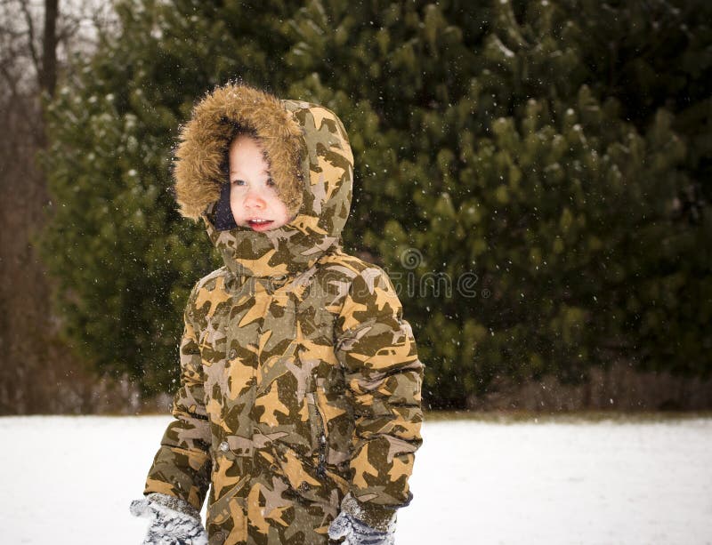Criança que joga na neve foto de stock royalty free Criança que joga na neve foto de stock royalty free