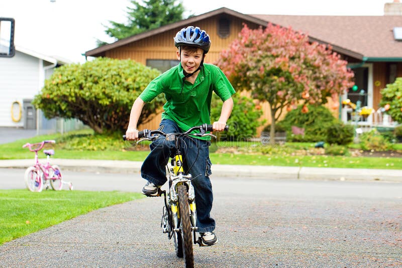 Criança que monta uma bicicleta
