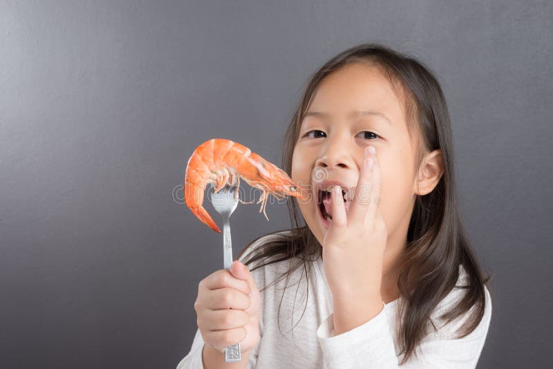 Crianças asiáticas bonitos ou menina da criança que come o camarão foto de stock Crianças asiáticas bonitos ou menina da criança que come o camarão foto de stock