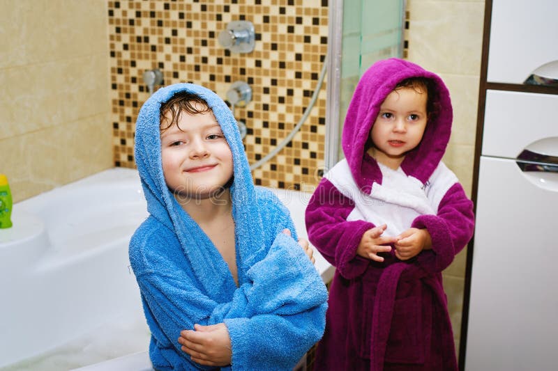 Brother and sister in the bathroom in bright robes. Brother and sister in the bathroom in bright robes